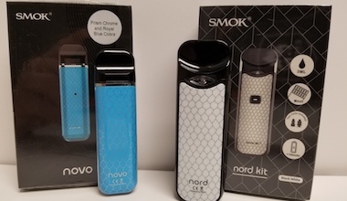 Blue Smok NOVO and White Smok NORD refillable vaporizers beside packaging