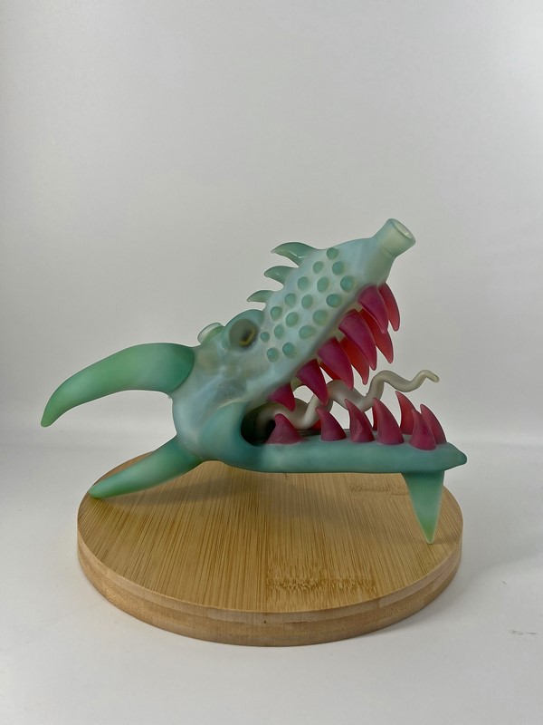 Heady glass pipe shaped like green sea-monster head with red teeth and long white tongue