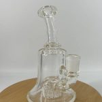 Transparent glass bong on circular wooden display board